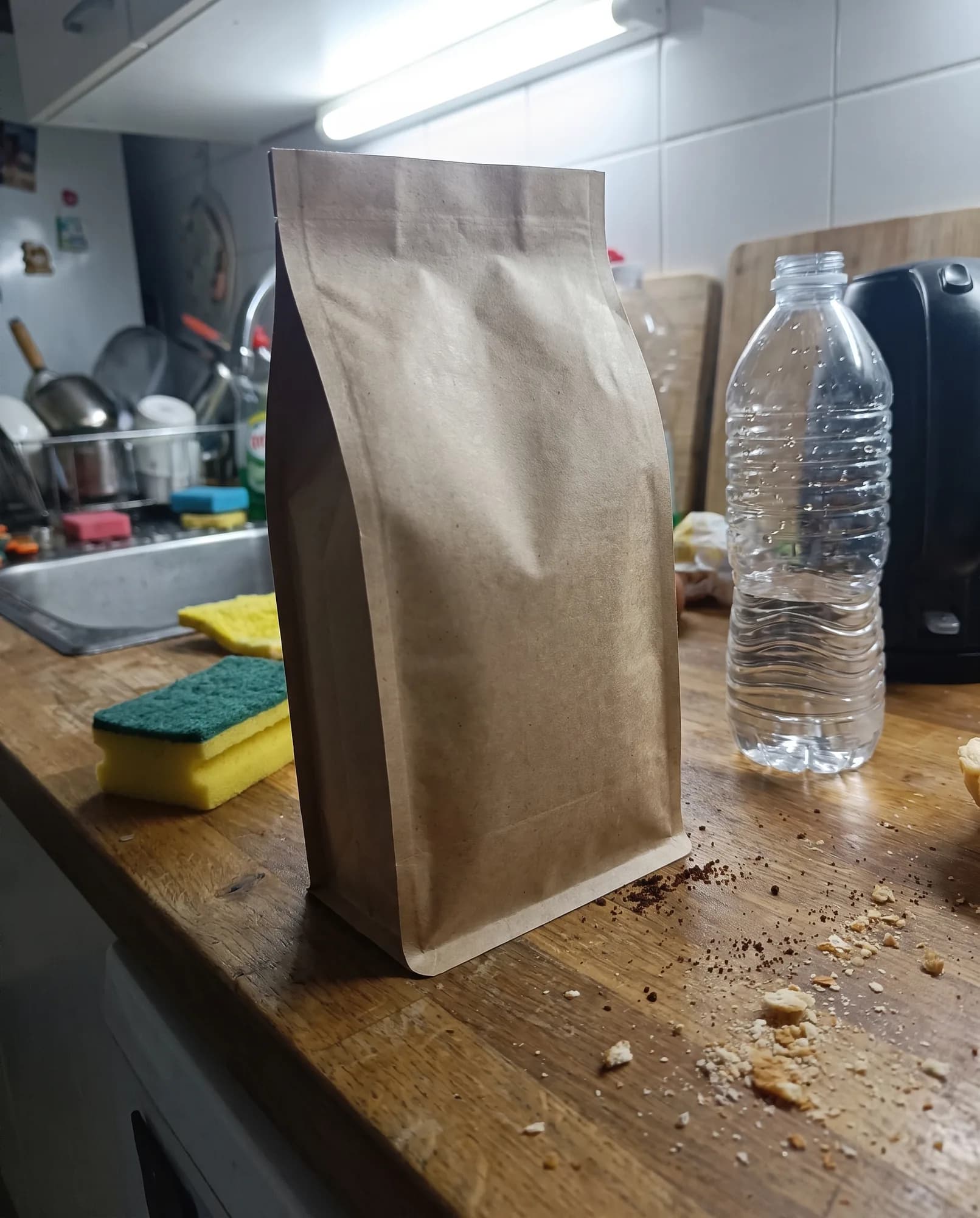 Antes: foto de celular do mesmo saco de café num balcão de cozinha, com luz fria