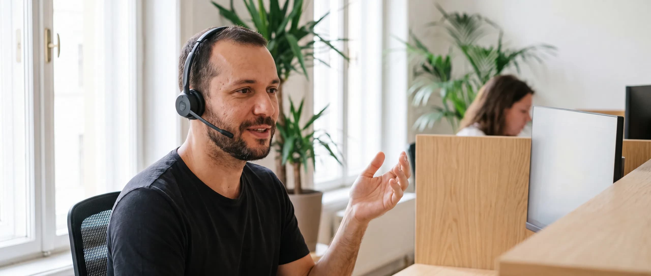 Analista de suporte com headset, ouvindo e explicando durante um atendimento