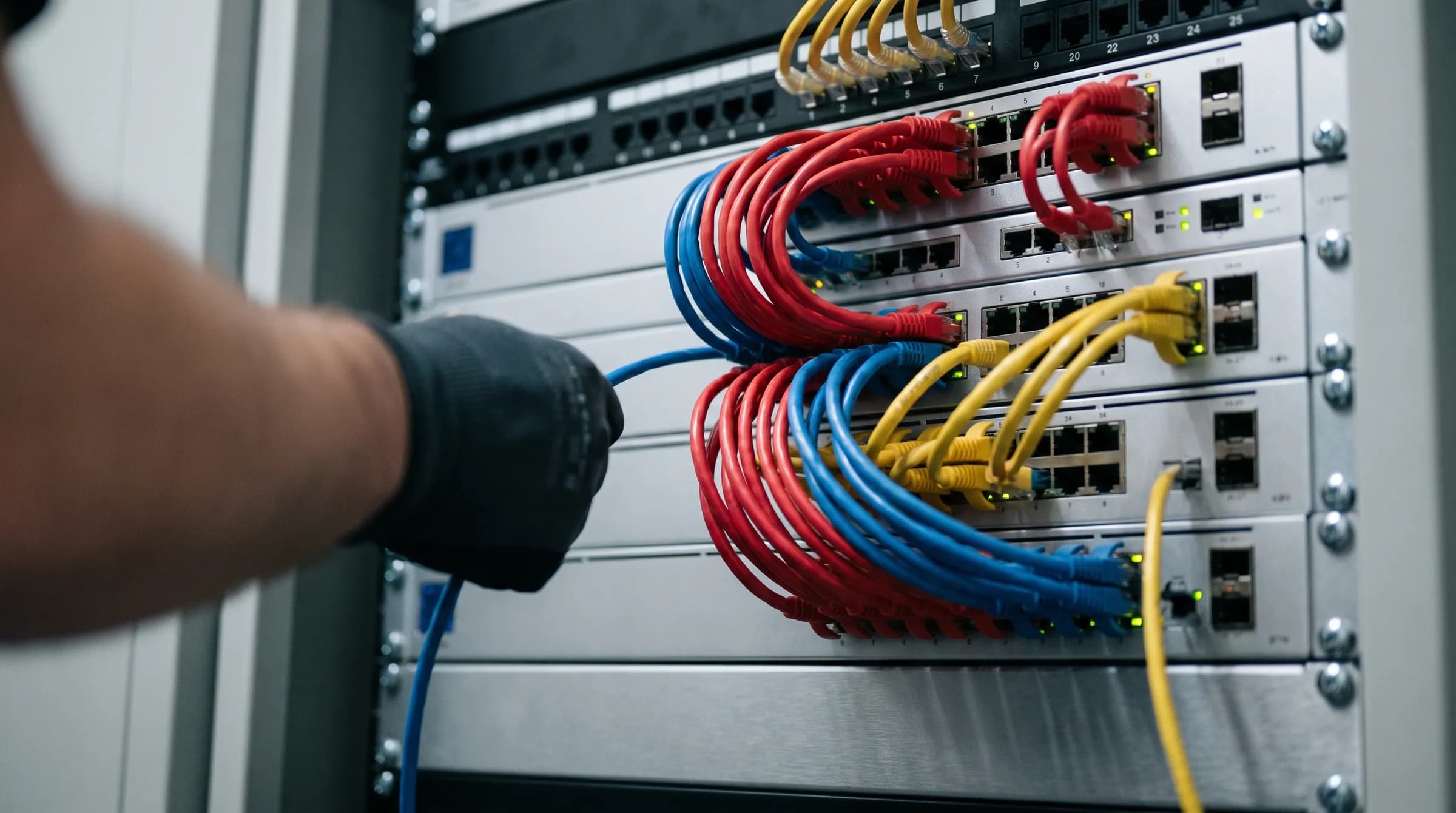 Cabos de rede organizados entrando nos switches de um rack